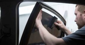 A man installing car window tint