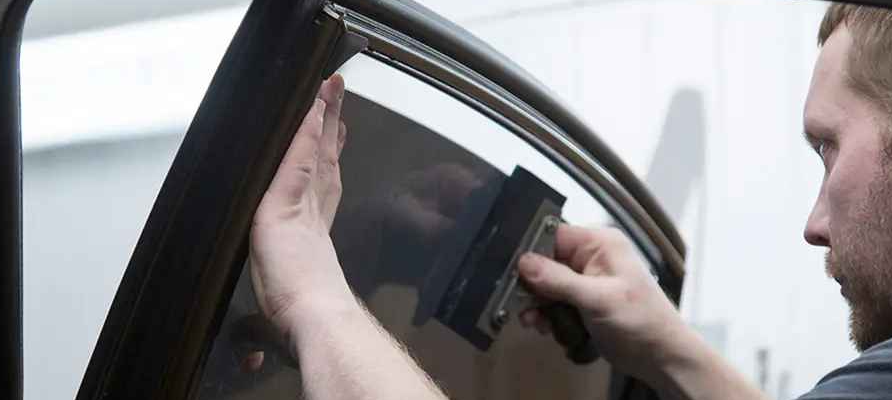 A man installing car window tint